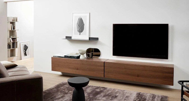 https://www.tlcinteriors.com.au/wp-content/uploads/2017/04/decorating-around-a-tv-set-with-long-brown-timber-floating-tv-unit-with-shelf-bedside-tv.webp
