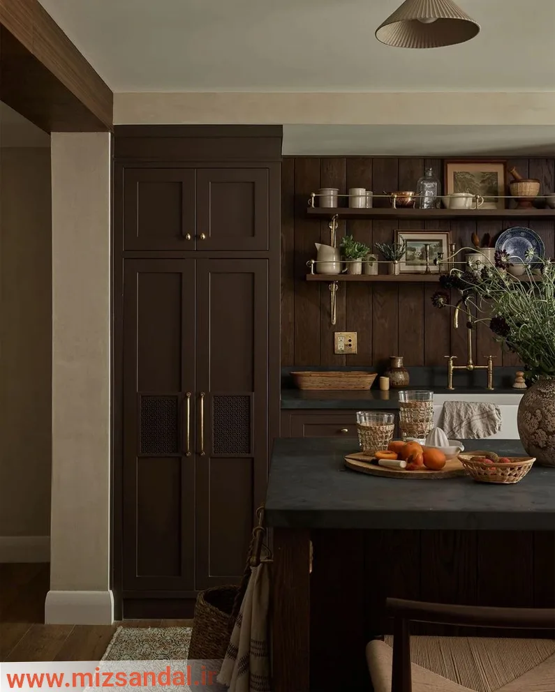 کابینت ممبران قهوه‌ای سوخته با دکور آشپزخانه- جهت زیباسازی فضا از اکسسوری‌های طبیعی مانند گل سبز و میوه نارنجی استفاده شده است.