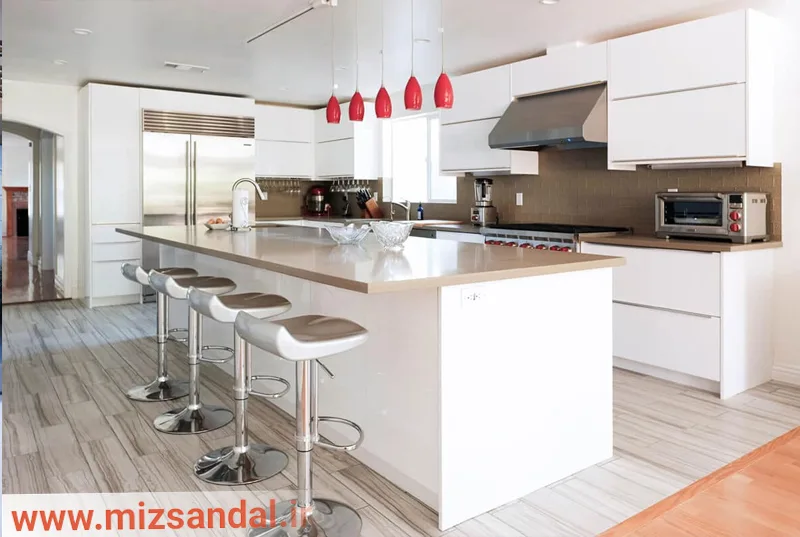 کابینت آشپزخانه هایگلاس سفید نقره ای با ترکیب رنگ قهوه‌ای نسکافه ای به عنوان کاشی بین کابینتی و اپن به عنوان میز ناهارخوری و پیشخوان